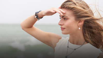 Model looking out the beach wearing Trollbeads bracelets, earrings and necklace